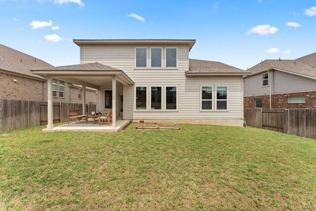 rear view of property featuring a fenced backyard, a lawn, and a patio area