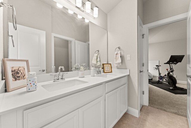 ensuite bathroom with double vanity, tile patterned flooring, a sink, and ensuite bathroom
