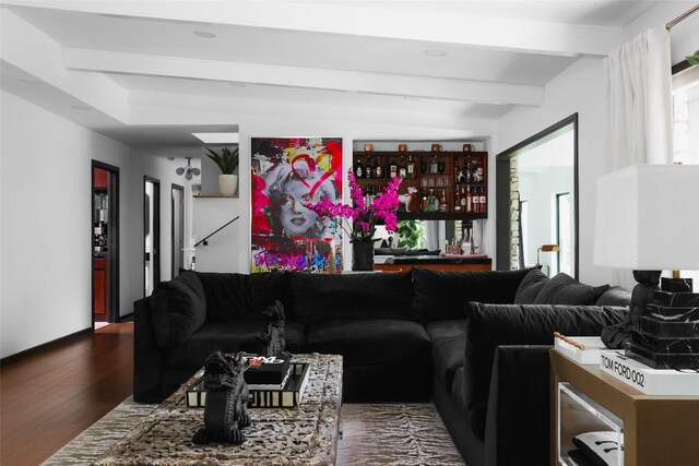 living room featuring baseboards, dark wood-style floors, and beamed ceiling