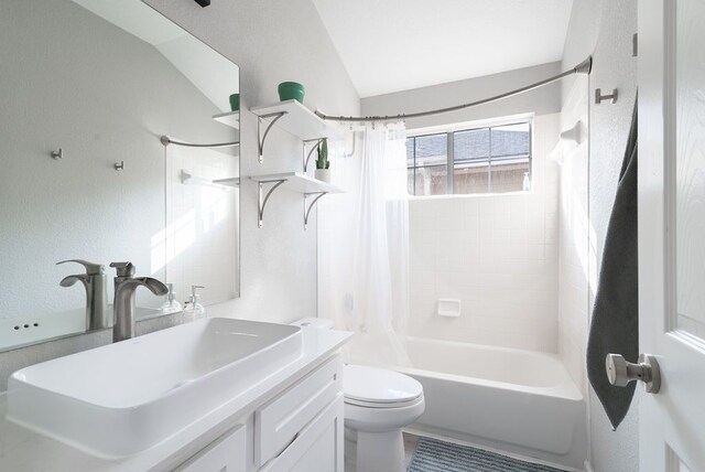 bathroom featuring toilet, vaulted ceiling, shower / bathtub combination with curtain, and vanity