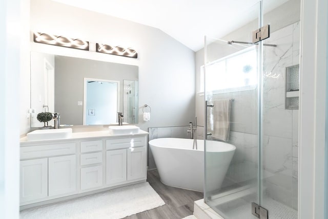 16100 S Great Oaks Dr Unit 3602, Round Rock, TX 78681 - full bath featuring a marble finish shower, double vanity, lofted ceiling, a freestanding bath, and wood finished floors