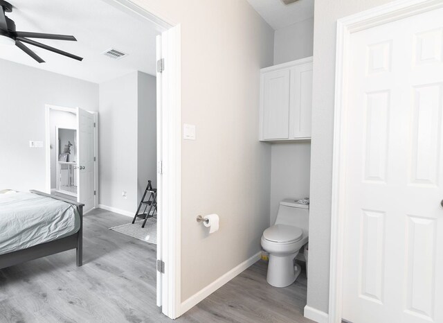 bathroom featuring visible vents, wood finished floors, toilet, baseboards, and ceiling fan
