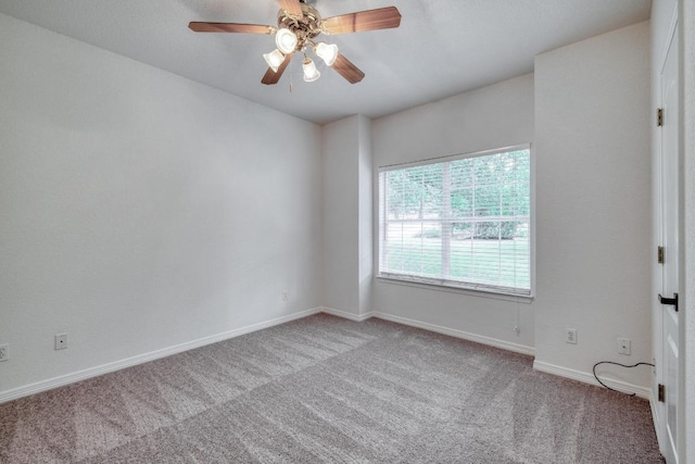carpeted spare room with baseboards and ceiling fan