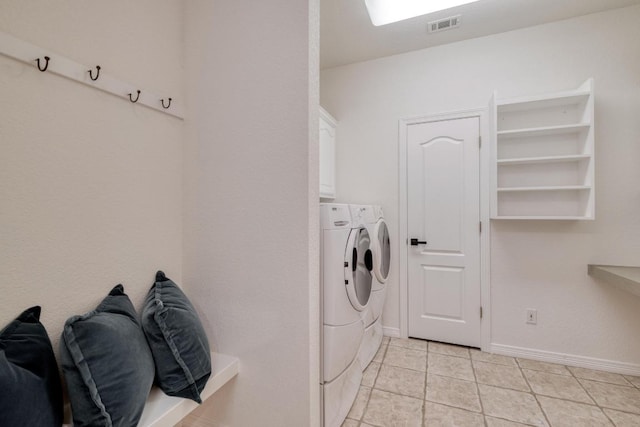 clothes washing area featuring cabinet space, separate washer and dryer, baseboards, light tile patterned floors, and visible vents