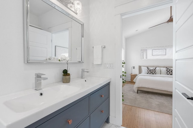 402 W 55th St Unit 2, Austin, TX 78751 - bathroom with double vanity, ensuite bathroom, lofted ceiling, and wood finished floors