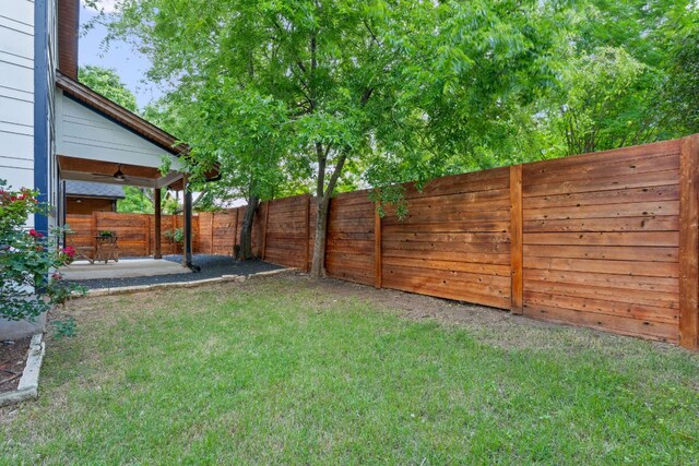 view of yard featuring a fenced backyard, ceiling fan, and a patio area