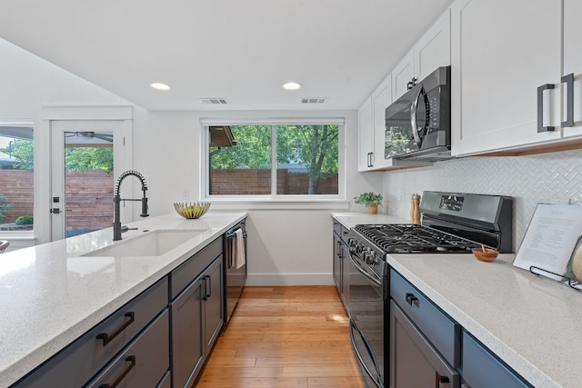 402 W 55th St Unit 2, Austin, TX 78751 - kitchen featuring stainless steel microwave, range with gas stovetop, a sink, baseboards, and dishwasher