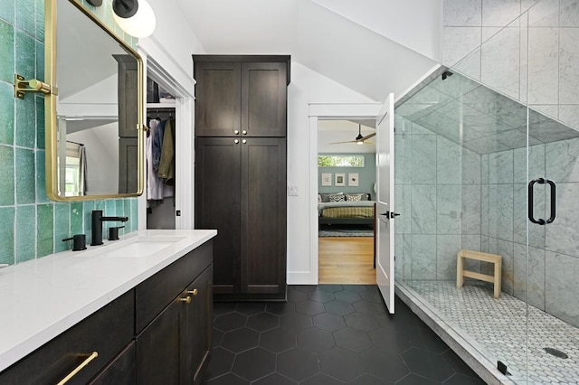 bathroom featuring tile patterned flooring, ceiling fan, a stall shower, and vaulted ceiling
