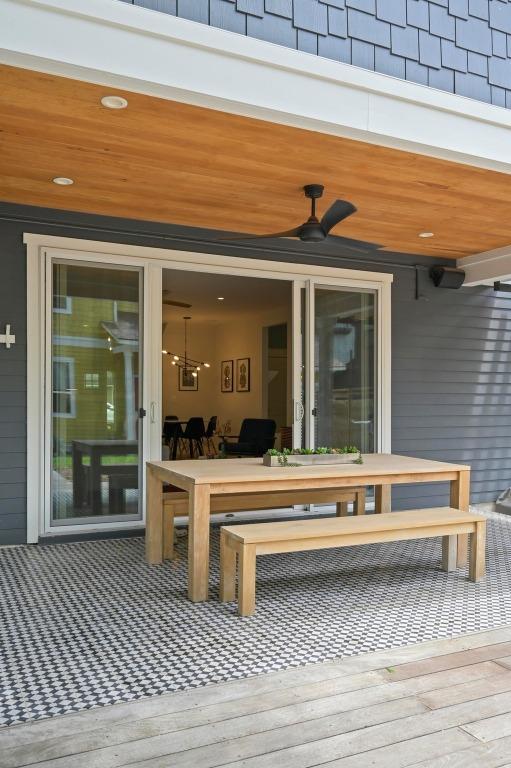 wooden deck with outdoor dining area and ceiling fan