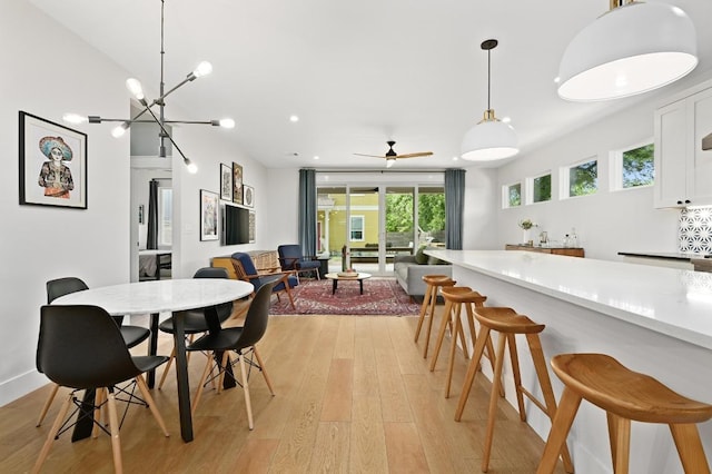 dining space with ceiling fan and light wood-type flooring