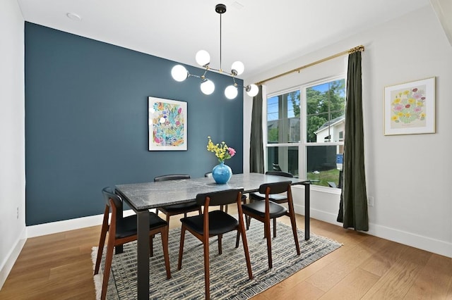 dining space with baseboards and wood finished floors