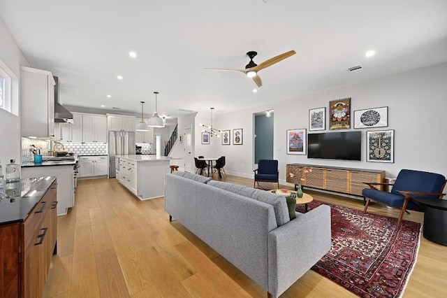 living room with a ceiling fan, visible vents, recessed lighting, and light wood-style floors