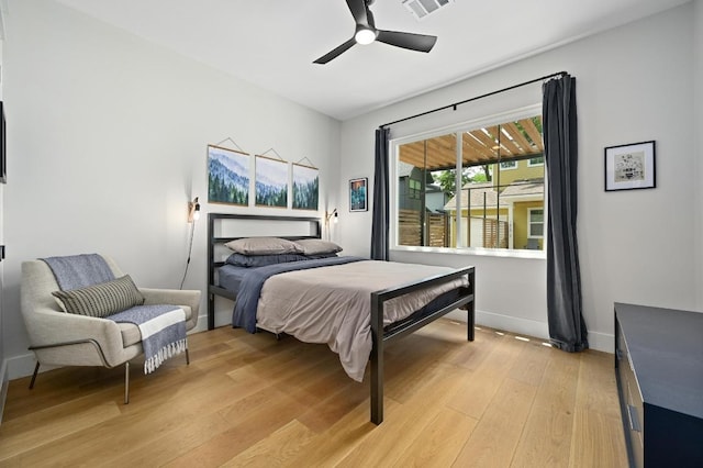 bedroom featuring baseboards, light wood-style flooring, ceiling fan, and visible vents