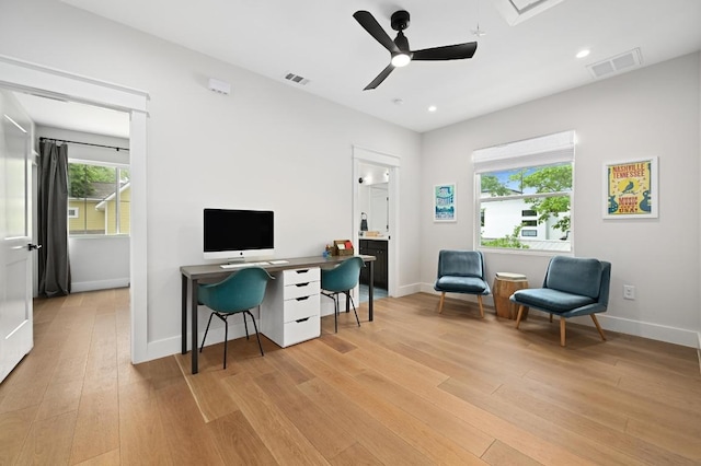 home office with a ceiling fan, baseboards, visible vents, and light wood-type flooring