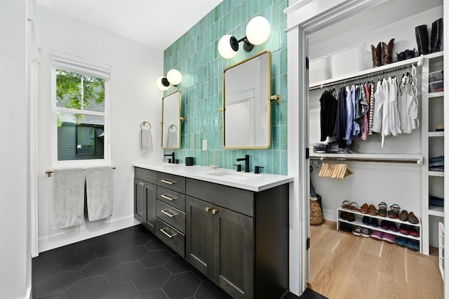 1815 Cullen Ave Unit 1, Austin, TX 78757 - full bath featuring double vanity, a spacious closet, tile walls, tile patterned flooring, and decorative backsplash