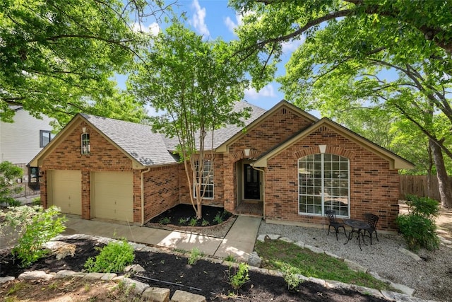 single story home with fence, a shingled roof, an attached garage, brick siding, and concrete driveway
