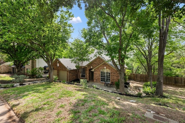 view of front of house with fence, an attached garage, and brick siding