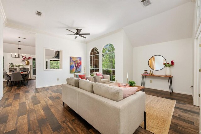living room with visible vents, ceiling fan with notable chandelier, and dark wood-style floors