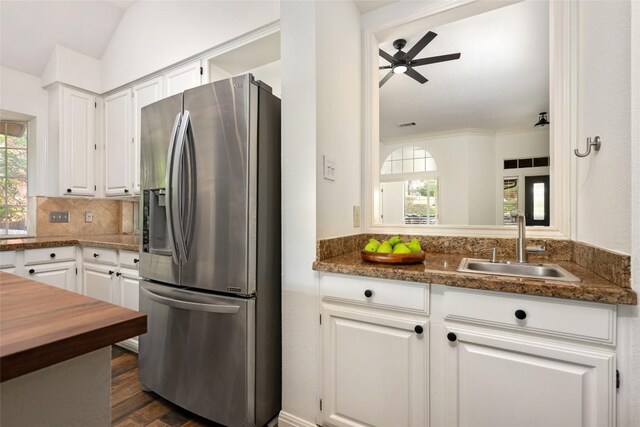 kitchen featuring vaulted ceiling, a wealth of natural light, a sink, and stainless steel fridge with ice dispenser