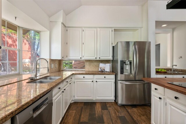 kitchen with a sink, dark wood-style floors, light stone countertops, and stainless steel appliances