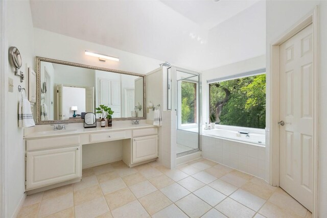 full bathroom with double vanity, a sink, a garden tub, and a stall shower