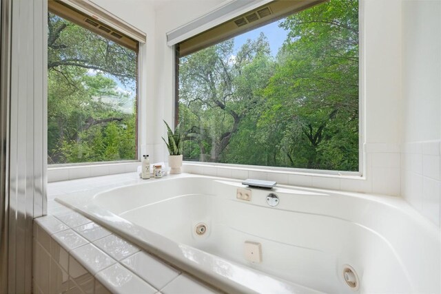 bathroom featuring a whirlpool tub and visible vents