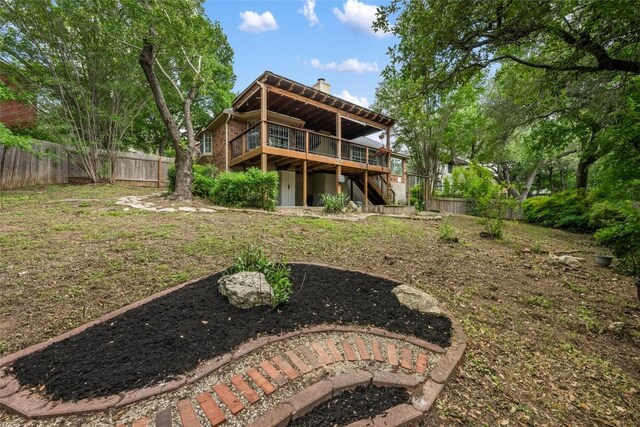 rear view of property with a fenced backyard, a wooden deck, a chimney, and stairs
