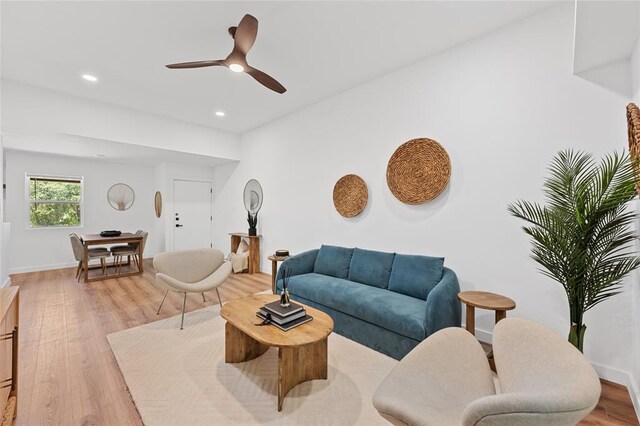 living room with light wood-style floors, baseboards, ceiling fan, and recessed lighting