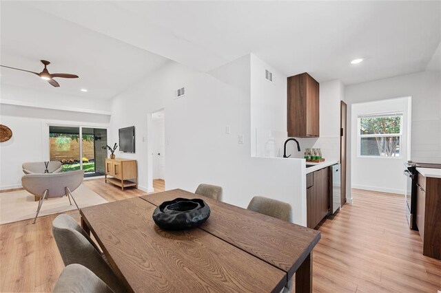 dining space with light wood-style floors, a wealth of natural light, and visible vents