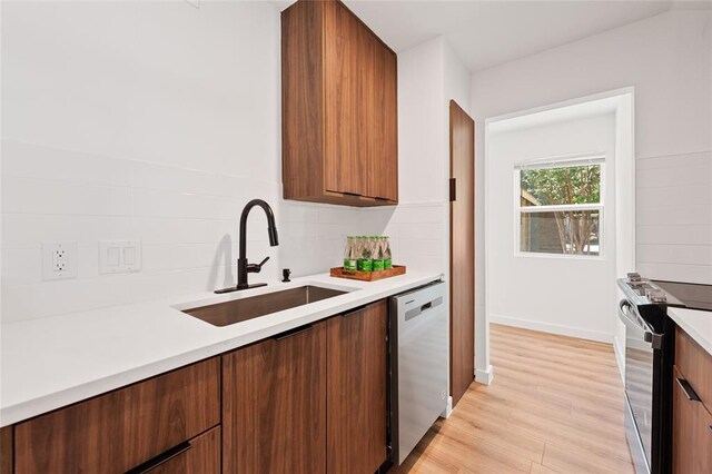 kitchen with range with electric cooktop, tasteful backsplash, stainless steel dishwasher, a sink, and light countertops