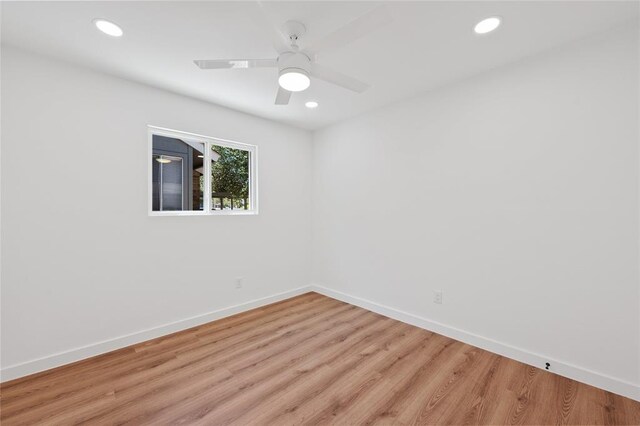 empty room featuring recessed lighting, baseboards, and light wood finished floors