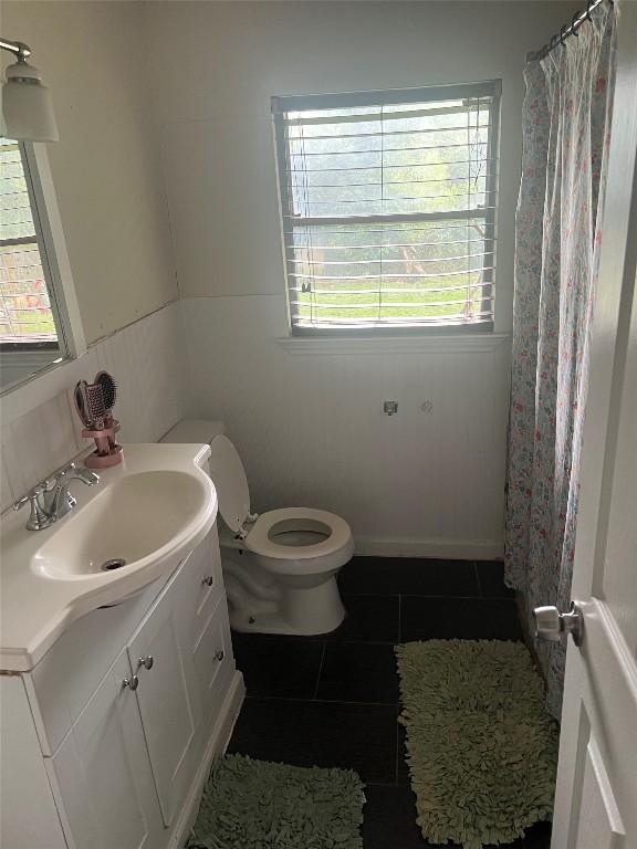 bathroom with toilet, a shower with curtain, tile patterned flooring, and vanity