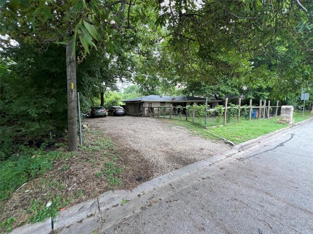 view of front facade featuring fence and driveway