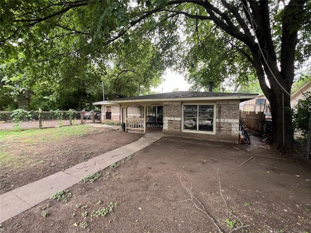 view of front of house featuring brick siding and fence
