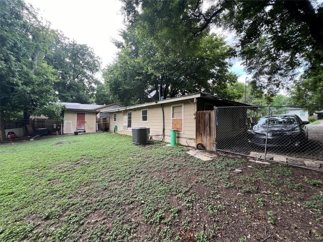 view of yard with central AC and fence