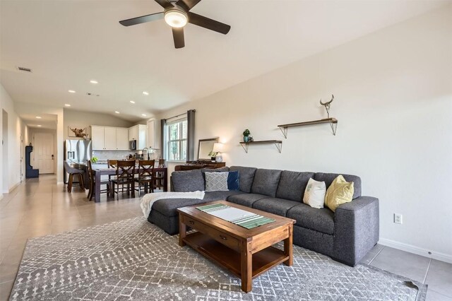 living room featuring light tile patterned flooring, a ceiling fan, recessed lighting, lofted ceiling, and visible vents