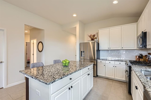733 Melda St, Leander, TX 78641 - kitchen with appliances with stainless steel finishes, tasteful backsplash, stone countertops, a center island, and light tile patterned floors