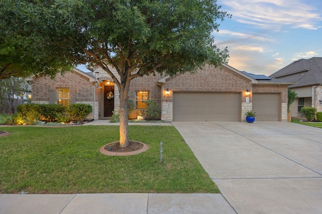 202 Parkwest Dr, Cedar Park, TX 78613 - view of front of home with brick siding, a garage, a front yard, roof mounted solar panels, and driveway