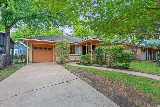 ranch-style home featuring fence, an attached garage, stone siding, a porch, and driveway