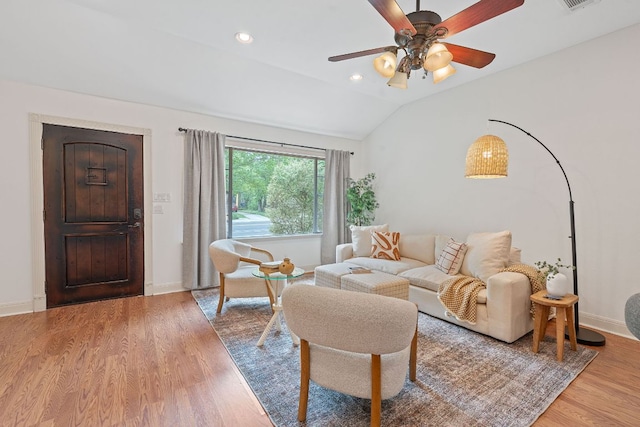 living area featuring ceiling fan, baseboards, wood finished floors, lofted ceiling, and visible vents