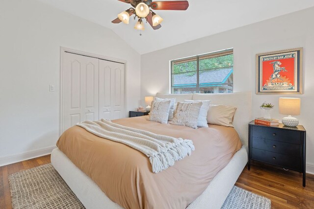 bedroom with a ceiling fan, wood finished floors, baseboards, a closet, and lofted ceiling