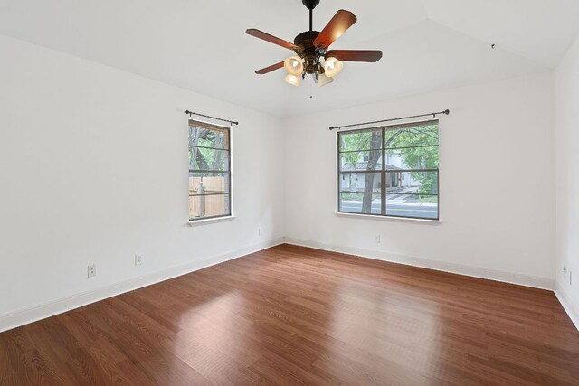 spare room with baseboards, ceiling fan, a healthy amount of sunlight, and wood finished floors