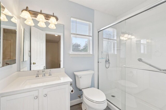 full bath featuring vanity, a chandelier, toilet, and a shower stall