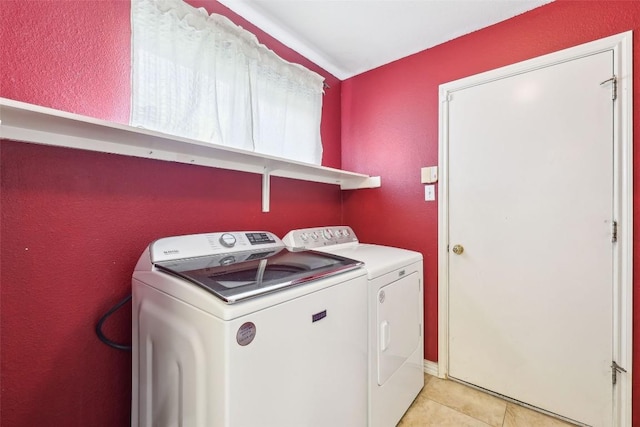 washroom featuring laundry area, washer and clothes dryer, and light tile patterned floors