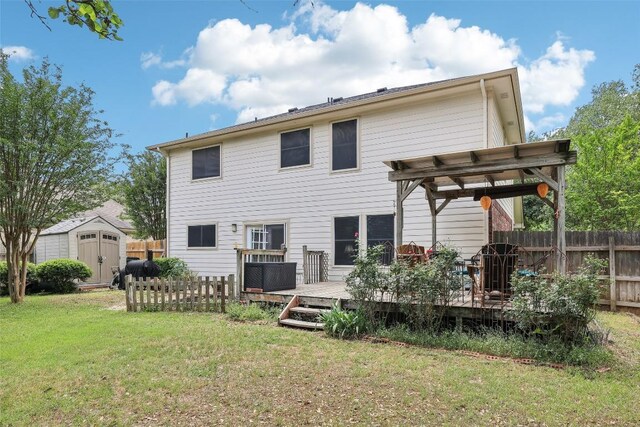 back of property with a deck, an outbuilding, fence, a shed, and a yard