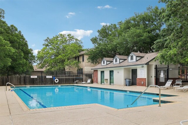 community pool featuring a patio area and fence