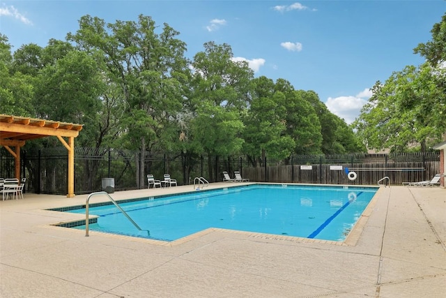 community pool with a patio area and fence