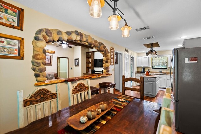 dining area with dark wood-style flooring, a ceiling fan, and visible vents