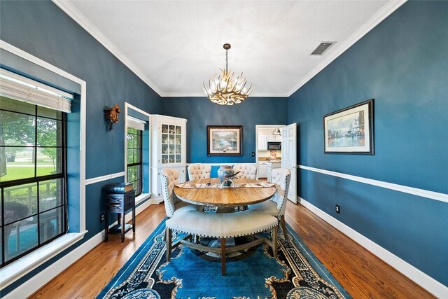 dining area featuring visible vents, baseboards, wood finished floors, and a chandelier