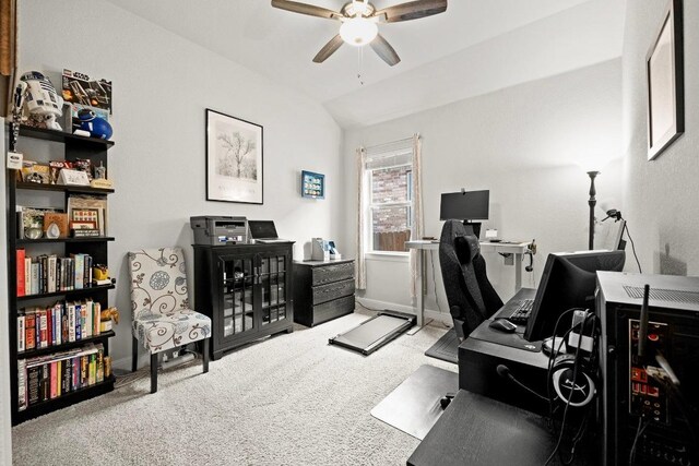 carpeted office space with baseboards, ceiling fan, and vaulted ceiling